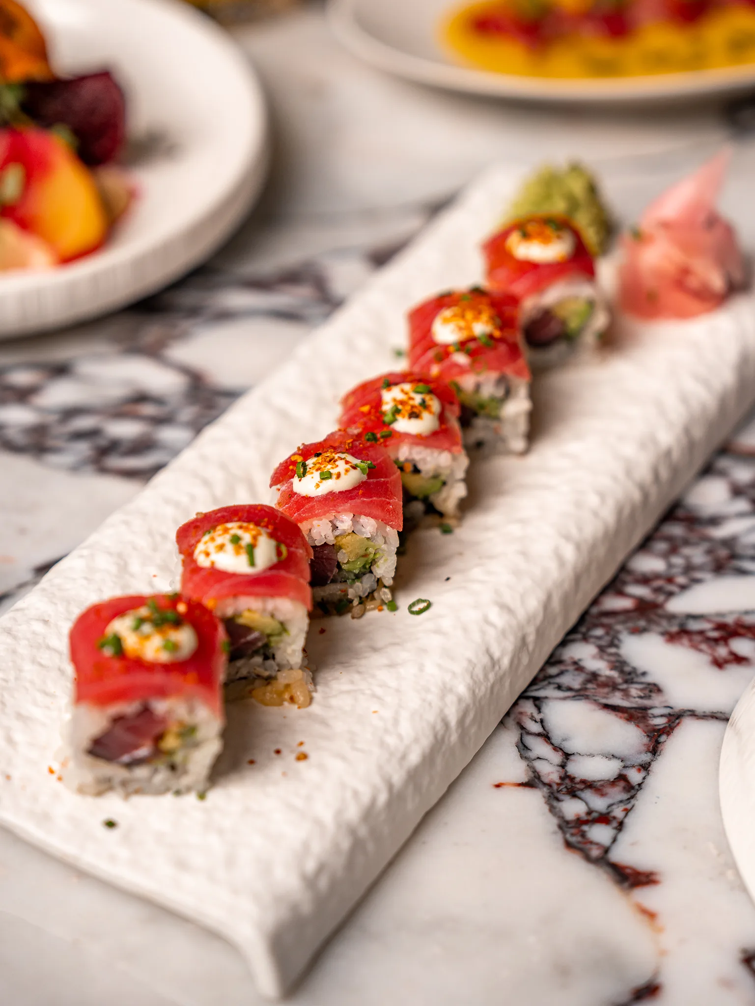 Tuna Maki - Fresh tuna and avocado wrapped in sushi rice, topped with raw tuna and our signature peruvian sauce.
